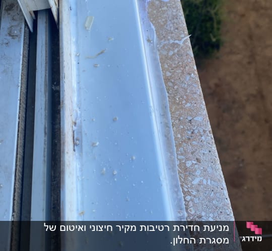 איטום חלון עם חומר לבן על מסגרת מתכת